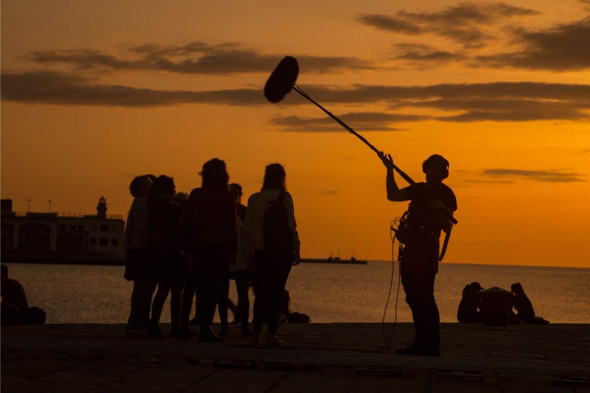 A film crew against a sunset sky
