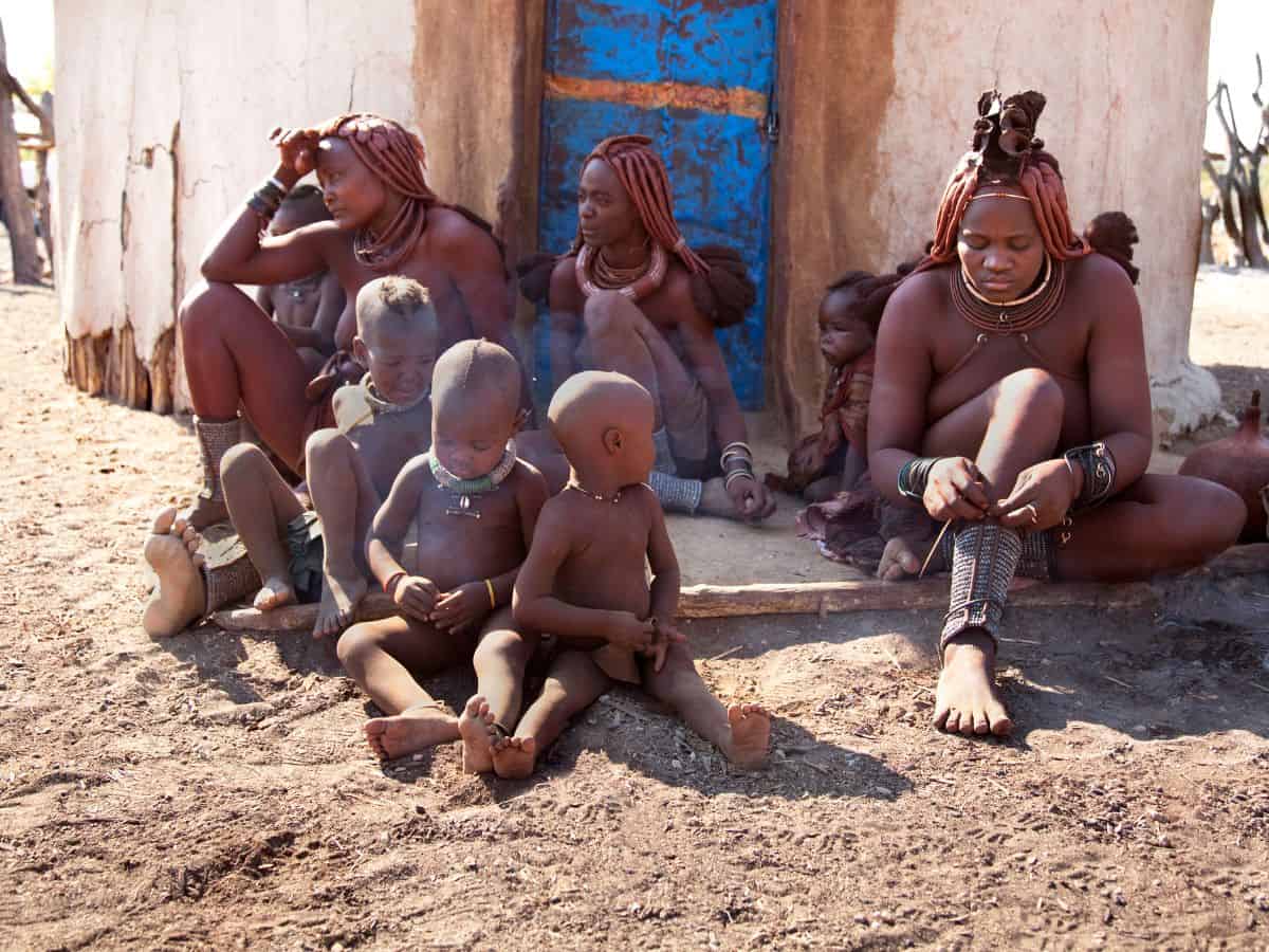 Himba tribespeople outside a hut in their village
