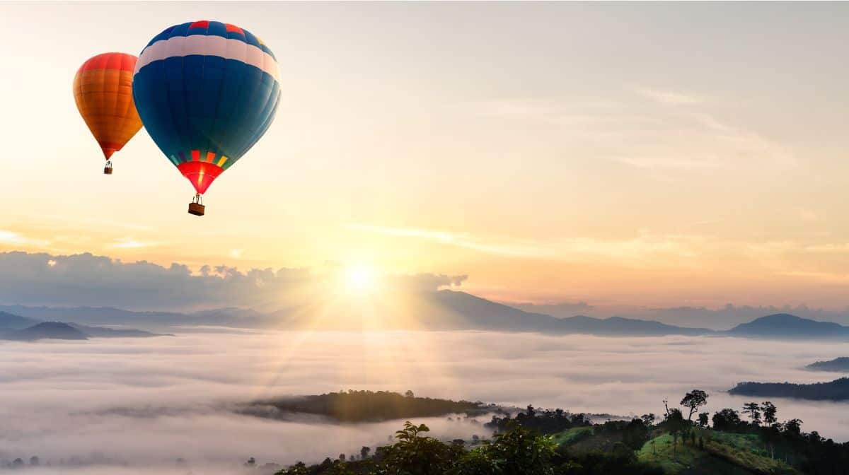 Hot air balloon above the clouds at sunrise