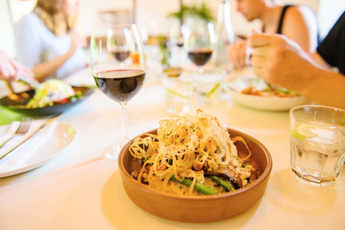 A vegetarian Rissotto at Cape Town Restaurant, with red wine in sparkling glasses on the table