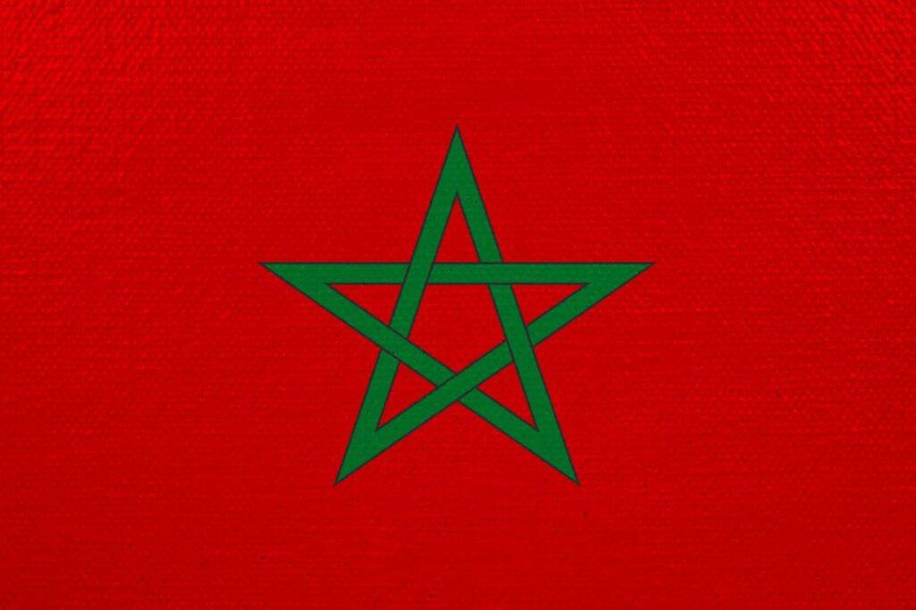 The Moroccan flag - a dark green 5 point star in the center of a  deep red background.