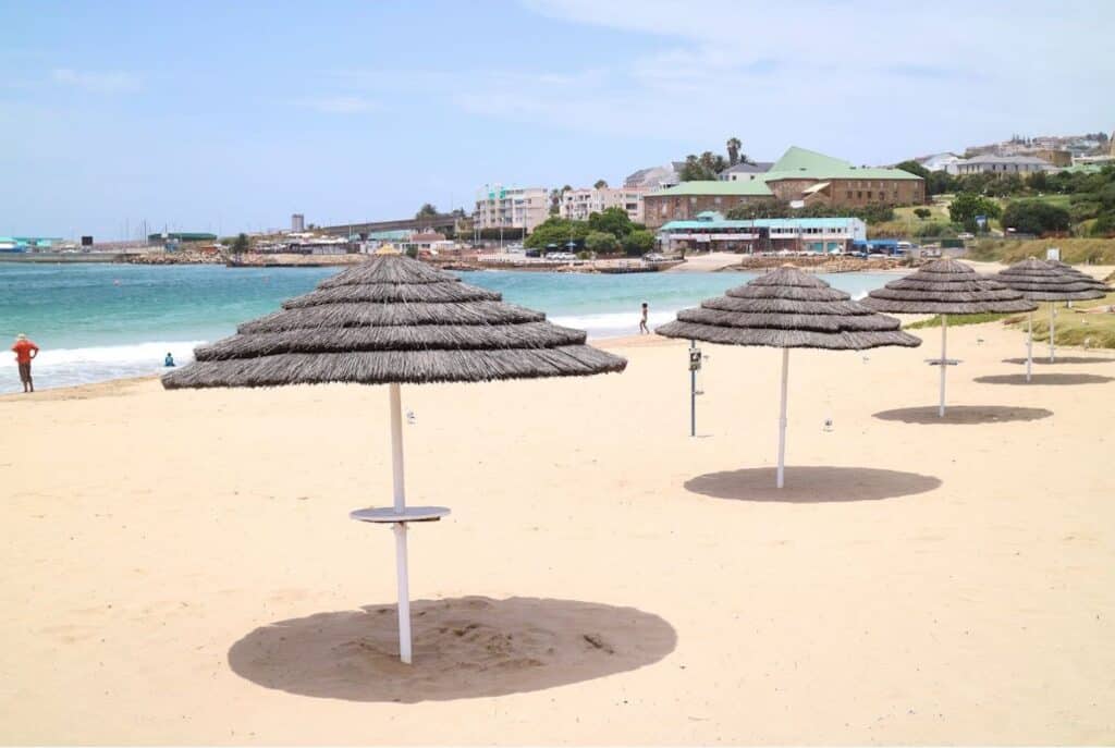 Stand-up bar beach umbrellas in the sand on Mossel Bay beach