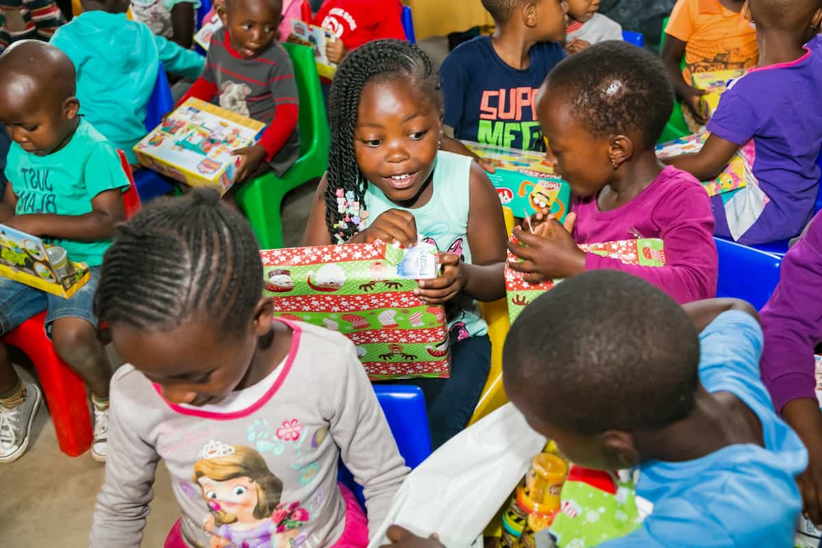 Young African school children in Johannesburg opening Christmas presents. DP