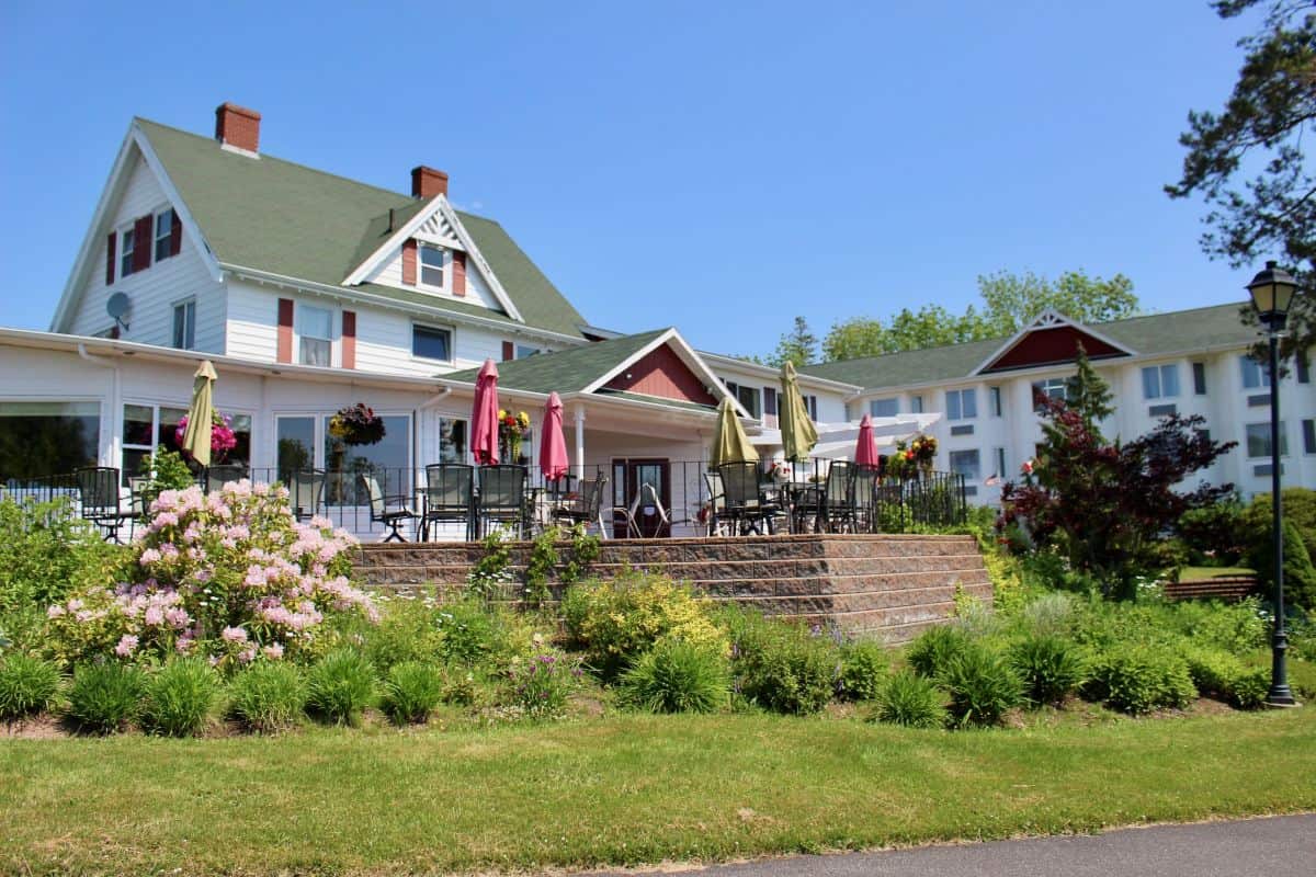 Auberge Gisele's Inn in Baddeck, under a bright blue sky